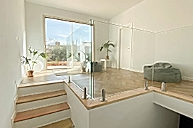 Bright living room with plants and comfortable poufs.