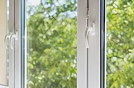 New plastic pvc window with white metal frame installed at modern house, view of blurred green trees