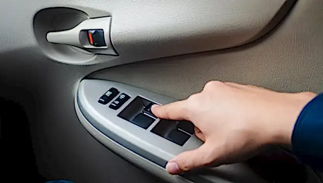 Closeup Driver's hand pressing Car window controls button.