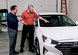 Glass Doctor professional showing car windshield to customer.